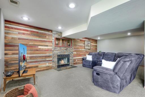 Escape to the lower level of the home with endless possibilities in this rec room with walkout to the back yard and wood burning fireplace.