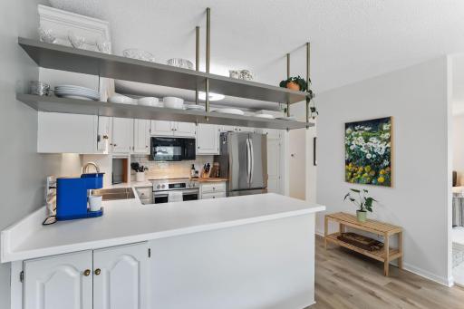 Stylish floating shelves add both charm and function to the kitchen space.