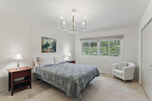 Ownerâs bedroom with new windows, updated light fixtures, and solar shades for comfort and style.
