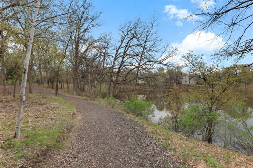 Trail alongside the pond creates a scenic path for peaceful walks and enjoying the view.