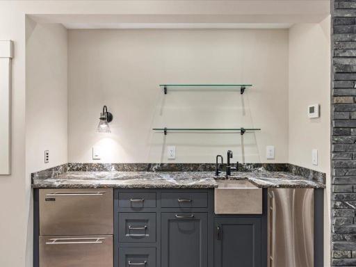 Built-in wet bar with refrigeration drawers and ice maker.