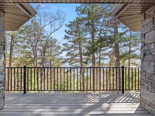 Primary suite deck lake views framed by tall pines.