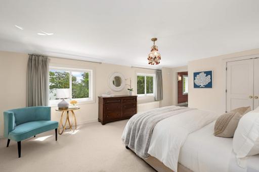 The primary bedroom has morning sunlight and overlooks the lake
