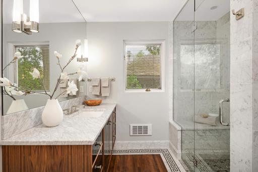 A stunning 3/4 hall bath has extraordinary finishes