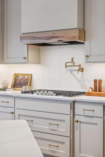 A designer tiled backsplash accents the gas cooktop.