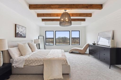 Wake up to peaceful pond views and unwind under the warm character of the designer light fixture and exposed beamsâthis Primary Suite feels like a relaxing getaway.