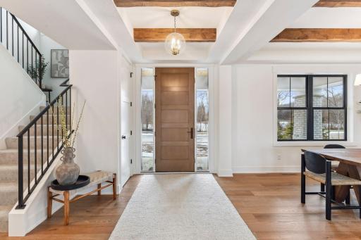 A warm welcome: natural wood tones, exposed beams, and clean lines create an entryway that feels both refined and inviting.