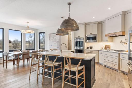 This chefâs kitchen blends timeless design with modern functionâhighlighted by brass fixtures, enameled custom cabinetry and statement lighting.