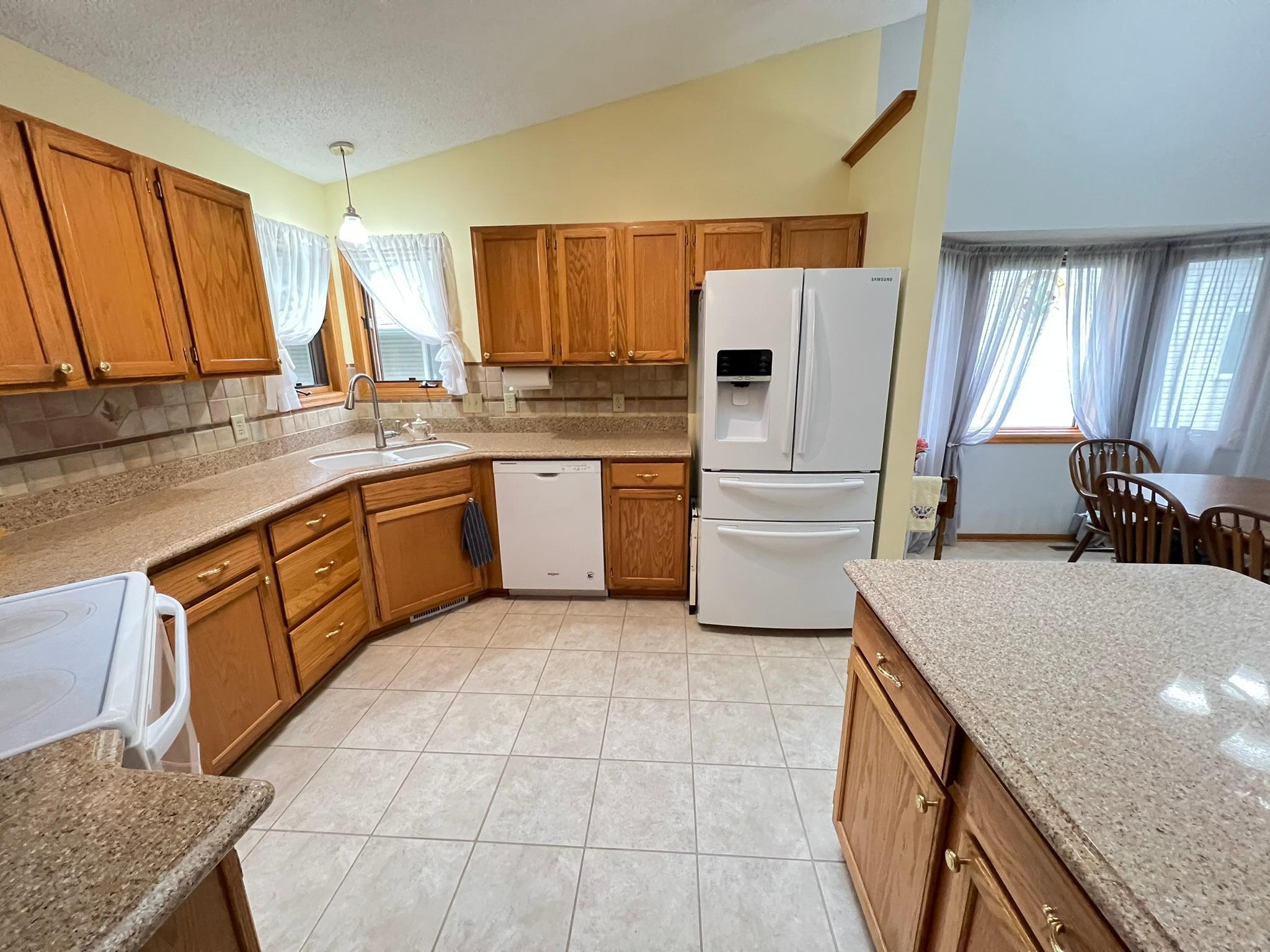 Spacious vaulted kitchen with ceramic tile flooring and granite counter tops.