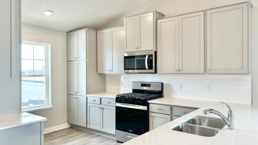 Photo of actual home! Ample countertop space for cooking, entertaining and seating. SS appliances. Microwave vented to the outside and more!