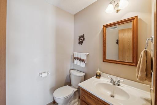 Convenient half bathroom with matching wood vanity and mirror