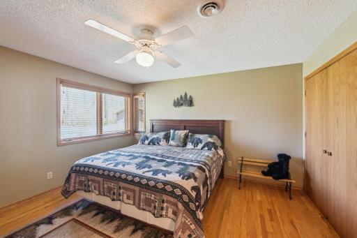 2nd bedroom with hardwood flooring, ample closet space, and views of the front yard.