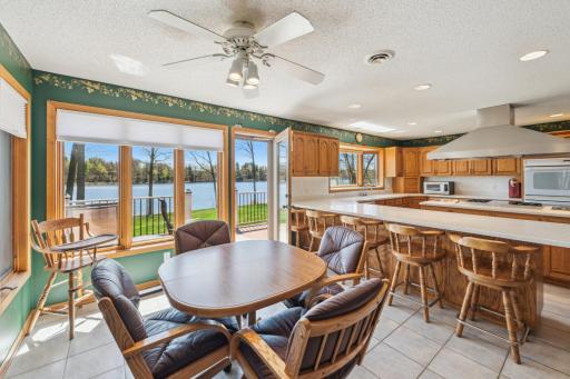 Informal dining area surrounded by windows with scenic views of Long Lake and direct access to the lakeside patio.