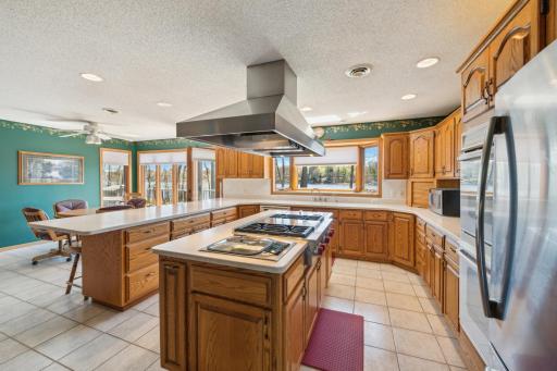 Spacious kitchen with abundant cabinet storage, wraparound countertops, and lake views from multiple angles.