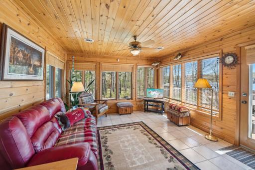 Inviting 4-season porch with knotty pine walls and forest views