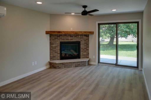 Wonderful gas fireplace with half brick surround and wooden mantel.