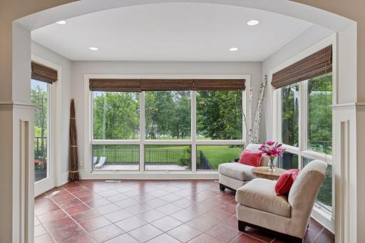 The sunroom overlooks the pool and lake. With heated floors, this space is sure to be cozy year round!