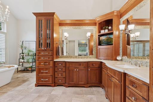 The spa-like primary bathroom features heated tile floors, custom cherry cabinet vanity with dual sinks, great lighting and an abundance of storage.