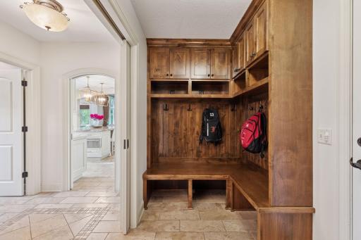 The mudroom offers a lot of storage and organization with the built-in bench and cabinets with hooks.