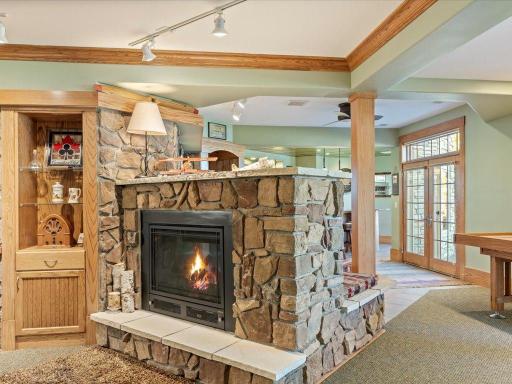 Lower Level two sided custom stone gas fireplace, and walk out to lower level lakeside patio