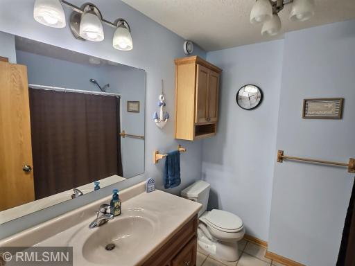 The lower level bathroom includes a tub and shower, tile floors, large vanity, and great lighting and storage options.