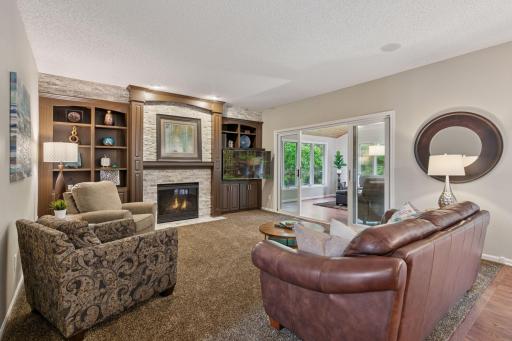 Exquisite blend of natural woods and stone~ family room opens to the four-season porch.