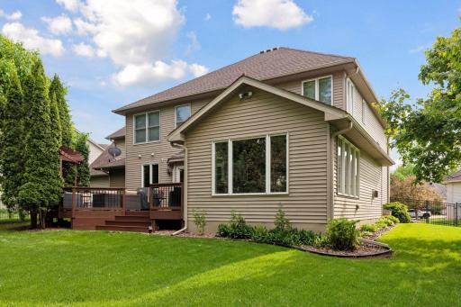 Backyard: Mature trees and green space wrapped in aluminum wrought iron fencing.