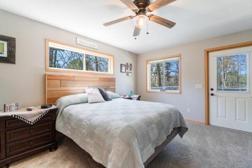 Primary bedroom on the main level with a door to go out to the deck that over looks the lake
