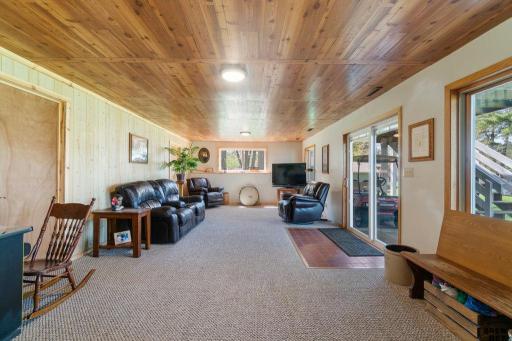 Family room area in the lower level with a walk out sliding door to the hot tub over looking the lake