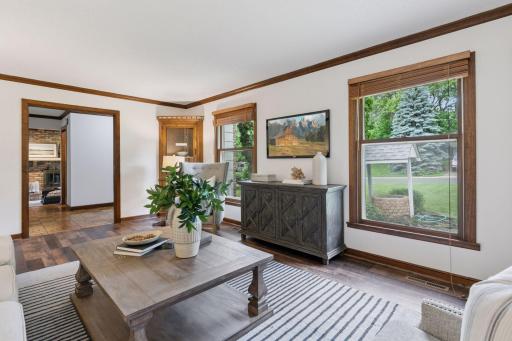 Sun-filled living room features crown molding, display-style built-in corner hutches, and French pocket doors—perfect for entertaining or relaxing in comfort