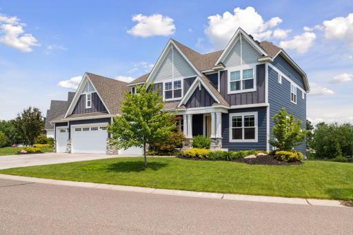 Appealing lush landscaping with the home dressed in an attractive color palette of Hardie board siding, brick accents and white trim.