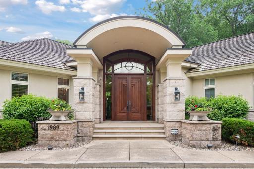 Inviting barrel vaulted entry with impressive columns and stunning wood front doors.