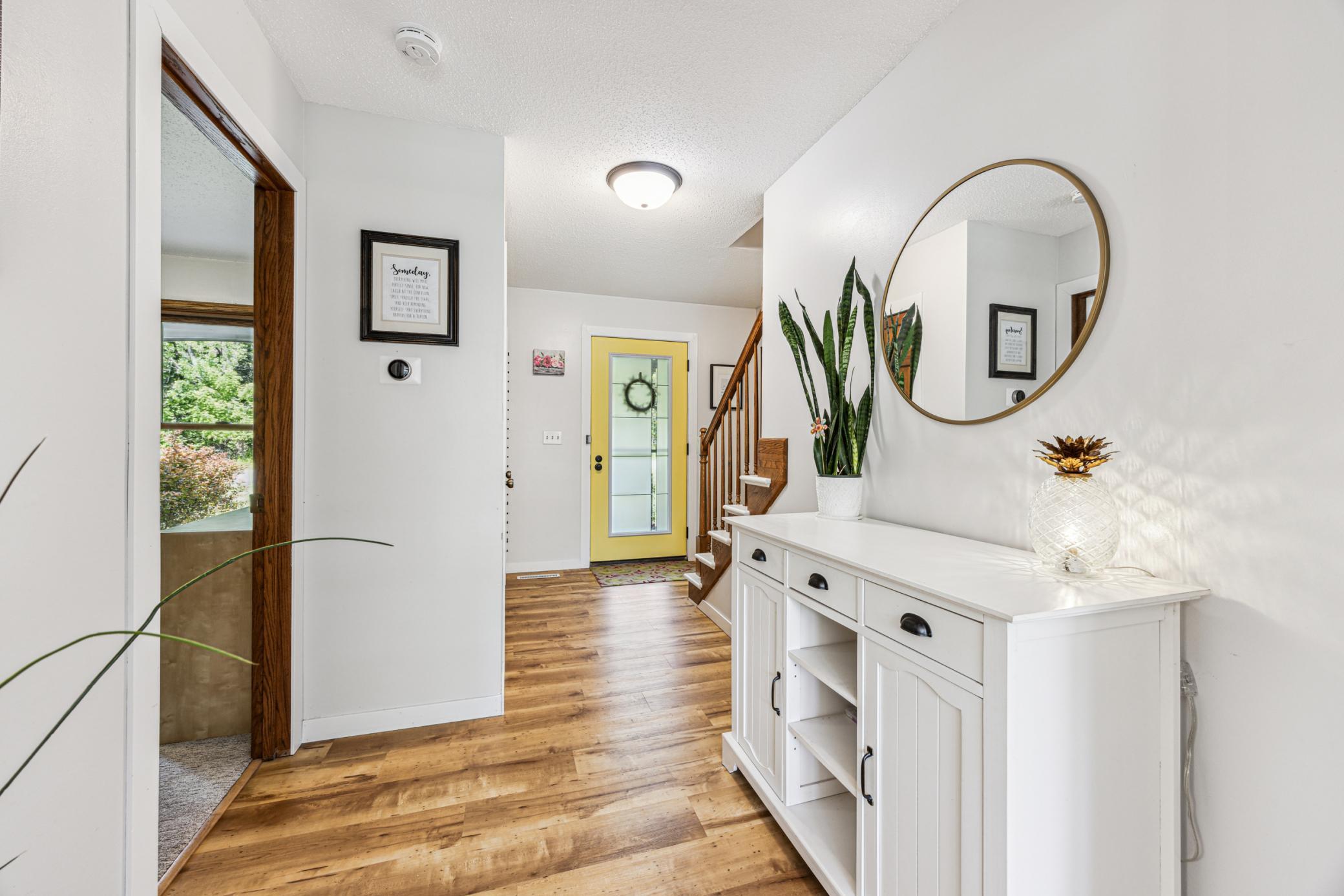 The foyer, with warm colors and wood-look LVP flooring, gives a warm and welcoming vibe from the moment you walk in.