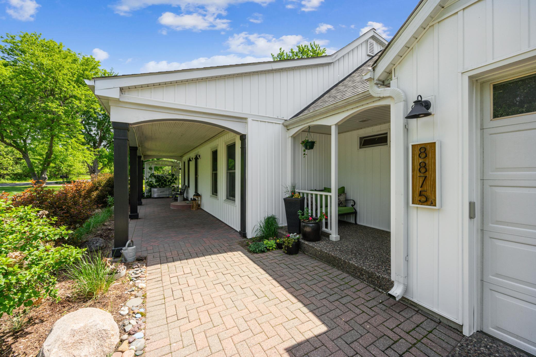 Approaching the home, you are welcomed by an expansive brick patio that seamlessly connects the side entrance with exposed aggregate to the main entrance featuring a covered patio.