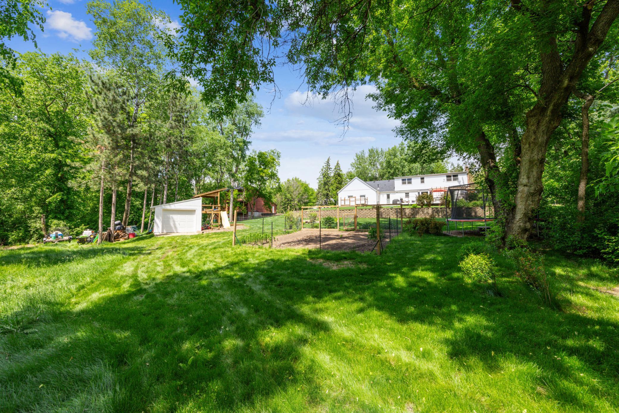 The lower back yard is lush with green grass, a fenced-in vegetable garden, bonfire pit & a large storage shed with electricity. Adjacent to the property sits over seven acres of city-owned land, providing privacy and scenic nature walks!