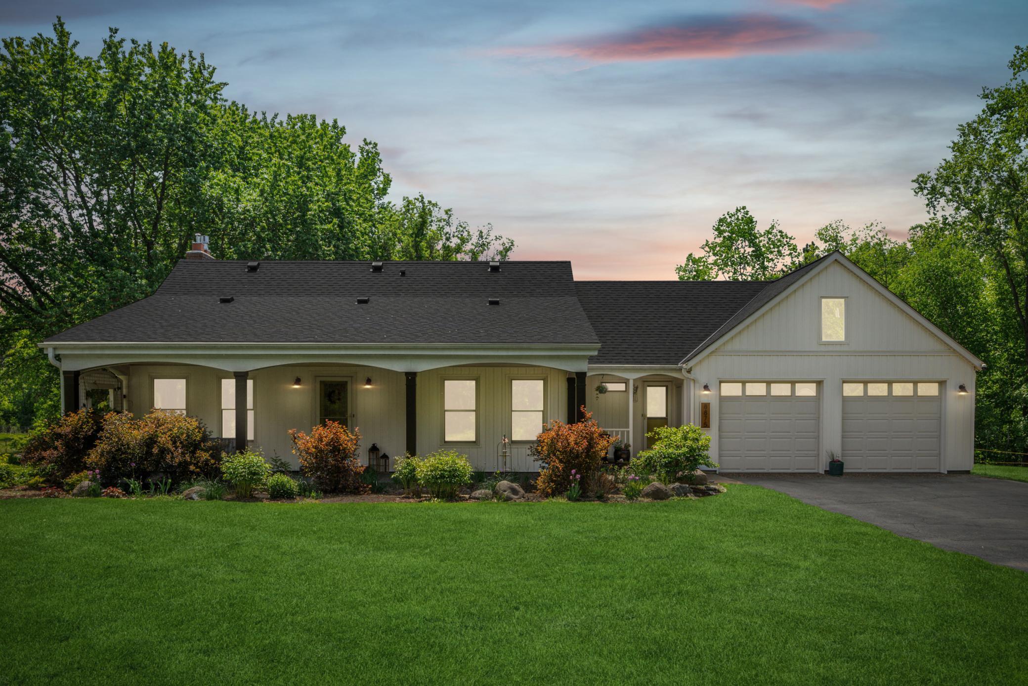 The front elevation showcases the home’s exceptional design alongside beautifully manicured landscaping and lush lawn.