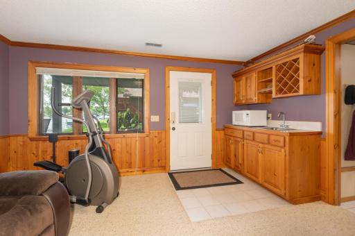 There is a wet bar and a door steps out to a huge paver patio and plush back yard. It is an easy stroll to the dock.