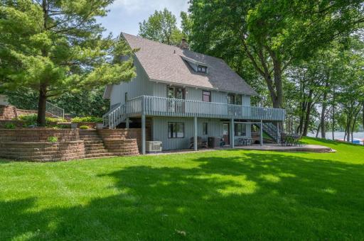 This is a wonderful setting with a plush lawn, beautiful landscaping and 130 feet of south facing lakeshore.