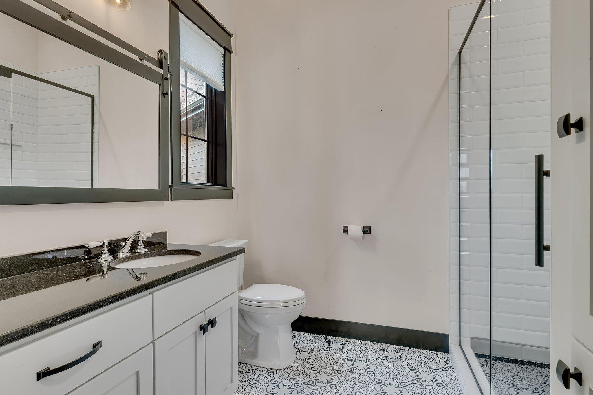 Steps from the guest main floor bedroom, a bath gives guests the feel of a private suite of their own.