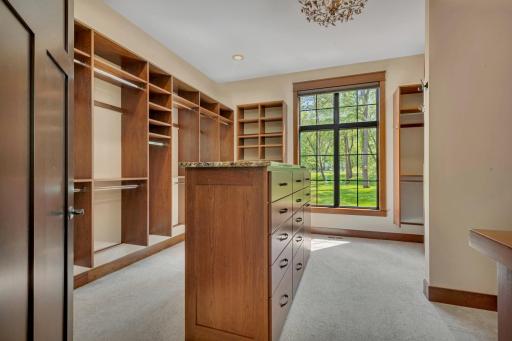 Walk-in closet featuring a central island with built-in drawers, providing stylish storage and easy organization.