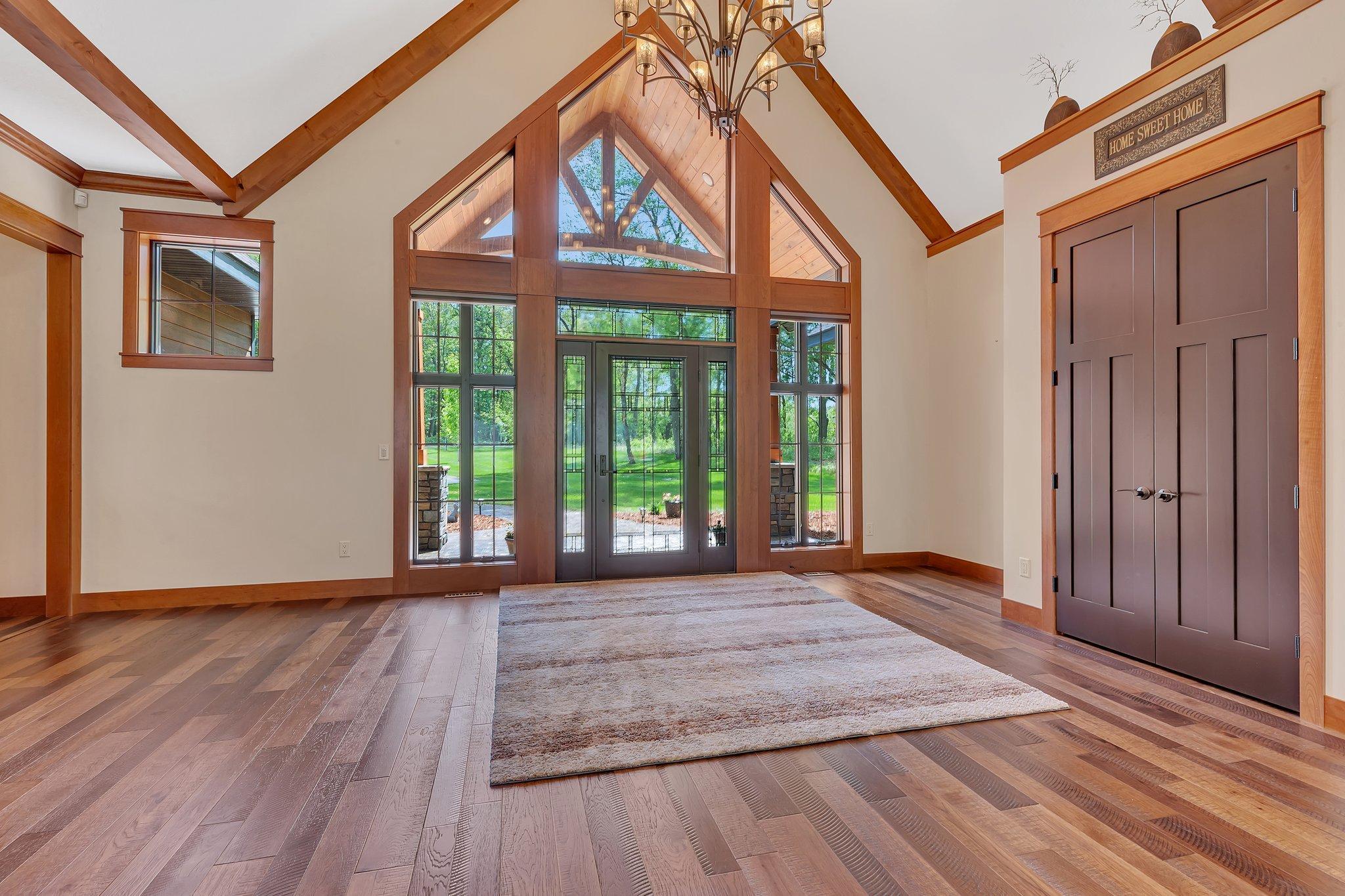 Vaulted grand entrance with abundant natural light streaming through large windows, creating a bright and welcoming atmosphere.