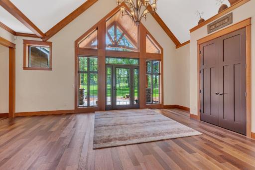 Vaulted grand entrance with abundant natural light streaming through large windows, creating a bright and welcoming atmosphere.