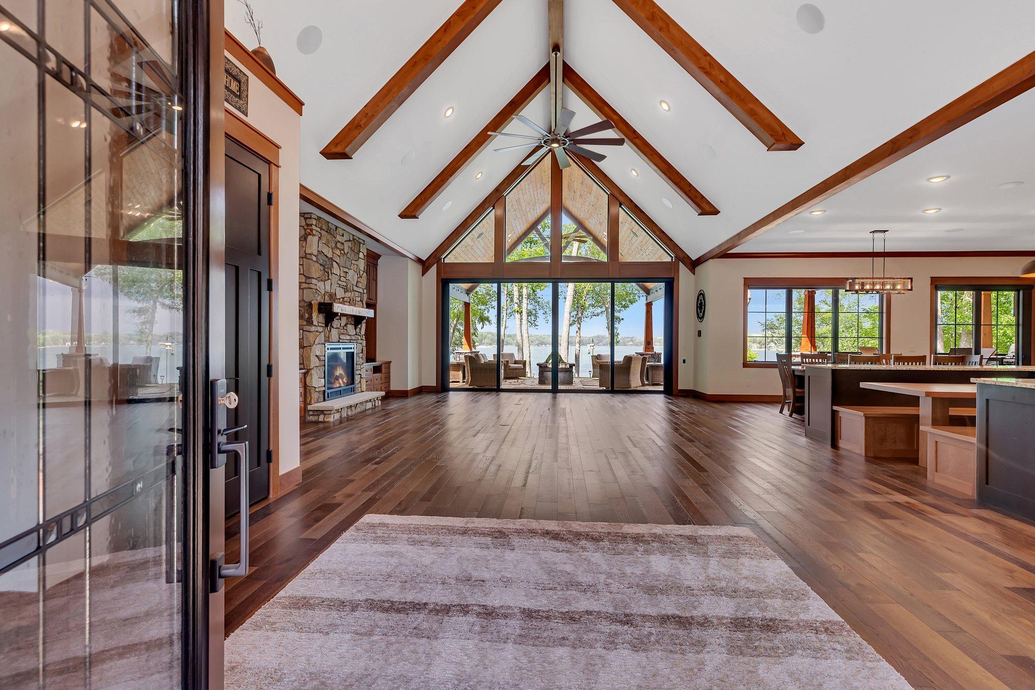 Step into the great room where expansive floor-to-ceiling windows Offer grand views of the lake.