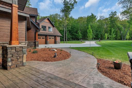 Beautifully landscaped front yard featuring a stamped concrete walkway and a durable concrete driveway, offering great curb appeal and a welcoming entrance.