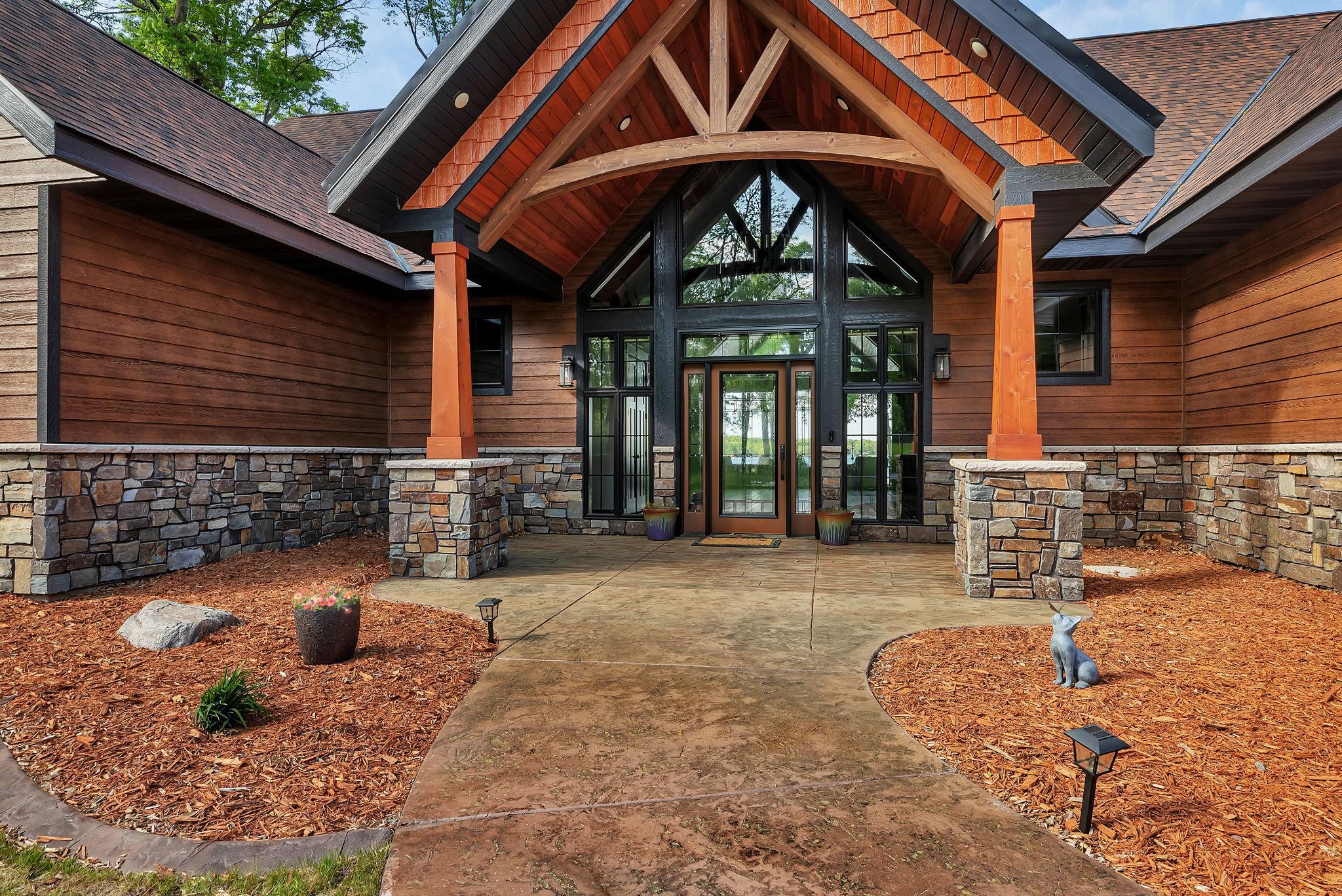 Grand entrance featuring a soaring covered entryway, elegant glass entry, and architectural details that create a striking first impression.