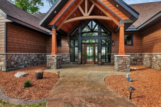 Grand entrance featuring a soaring covered entryway, elegant glass entry, and architectural details that create a striking first impression.