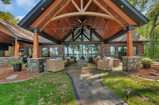 Vaulted, covered sitting area with a gas firepit, built-in speakers, and ambient lighting—perfect for relaxing or entertaining in any season.