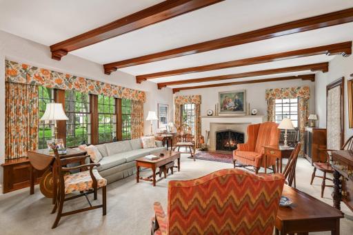 The lovely living room has mahogany beamed ceilings and is fulled with windows