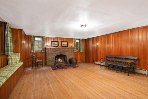The step-down family room features a beautiful brick fireplace and hardwood floors