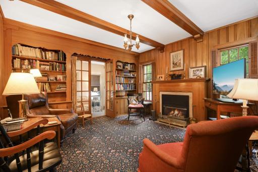 The stunning main floor Study has mahogany paneling, a fireplace with a gas insert and French doors to the porch